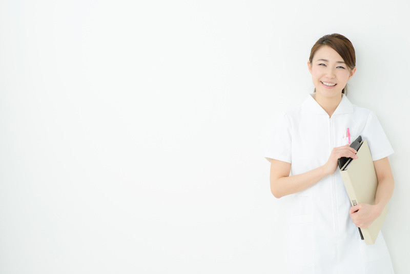 白い制服を着てにこやかにこちらに笑いかけている女性介護士